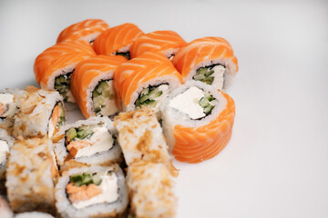 Sushi set with salmon, tuna and cream cheese close-up. Traditional Japanese cuisine side view.