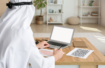 Male Arab calligraphist working in office