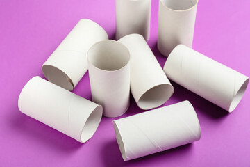 Toilet paper cardboard tubes on purple background, closeup