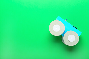 Car made of toilet paper tubes on green background