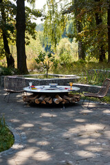 Fototapeta na wymiar Kettle Grill Pit with Cast Iron Grid with flames . Round table-cooking surface. Hot BBQ on Backyard
