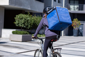 delivery woman riding bicycle in city
