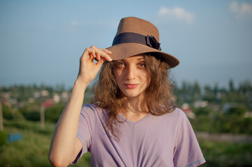 Young girl in dress is having great time during vacation in the summer on sky background in nature, travelling concept