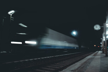 Treno che passa la stazione in Italia di notte.