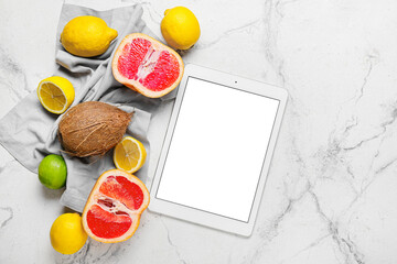 Digital recipe book and different fruits on light marble background