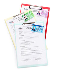 Clipboards with rental agreements and driver licenses on white background