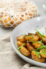 Potato wedges, oven roasted close up on light concrete background. Roasted baby potatoes. fries potatoes with green onions.