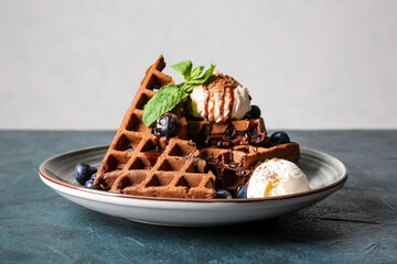 Plate of delicious Chocolate Belgian Waffles with ice cream and blueberry on table