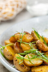 Potato wedges, oven roasted close up on light concrete background. Roasted baby potatoes. fries potatoes with green onions.