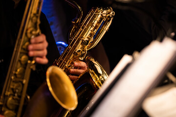 A baritone saxophone player getting his groove while playing in a sax section of a big band during a live concert performance