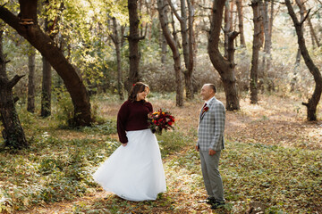 walk of the bride and groom through the autumn forest