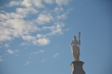 Statue of a girl with a paddle on a background of clouds. Russia, St.Peterburg 