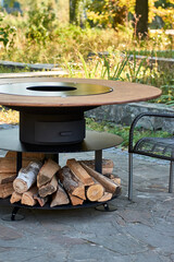 Kettle Grill Pit with Cast Iron Grid with flames . Round table-cooking surface. Hot BBQ on Backyard