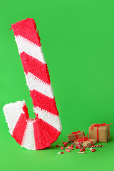 Fototapeta na wymiar Mexican pinata with gifts and candies on green background