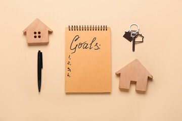 Notebook with empty to do list, key and models of house on color background. New year goals