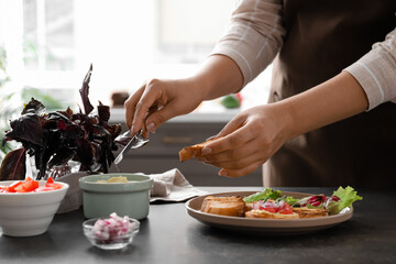 Woman cooking delicious vegetarian bruschettas at table in kitchen