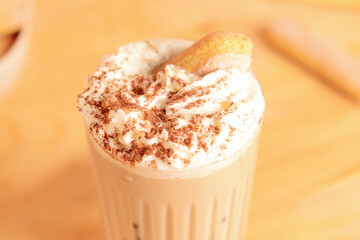 Glass of tasty Tiramisu Latte on table, closeup