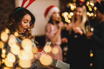 Woman Using Smartphone While Celebrating Holidays With Her Friends At Home