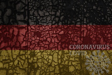 flag of germany on a old metal rusty cracked wall with text coronavirus, covid, and virus picture.