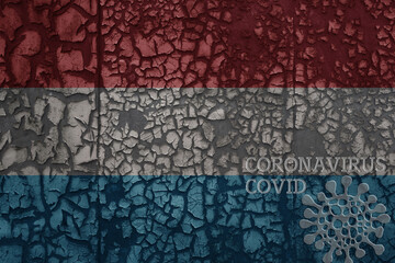 flag of luxembourg on a old metal rusty cracked wall with text coronavirus, covid, and virus picture.