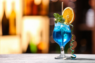 Glass of Blue Lagoon cocktail on table in bar