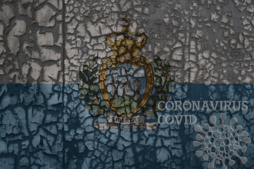 flag of san marino on a old metal rusty cracked wall with text coronavirus, covid, and virus picture.