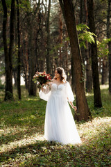 Obraz na płótnie Canvas girl in a wedding dress in the autumn forest
