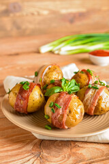 Plate of tasty baked potatoes with bacon on wooden background