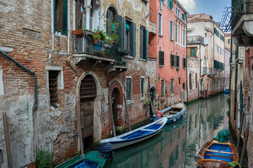 Obraz na płótnie Canvas One of Venice's many canals with small boats lying ready.