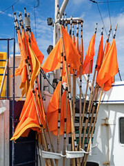 Orange Fahnen als Markierung von Fischernetzen an Bord eines Fischerbootes im Hafen von Hanstholm, Dänemark