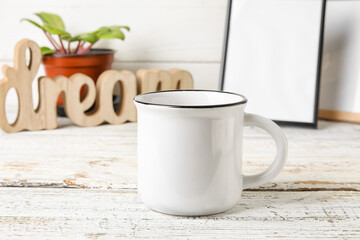 Stylish blank cup on light wooden background