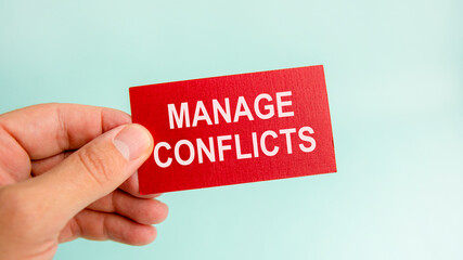message on the card with text manage conflicts, in hand of businessman.