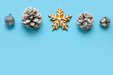 Fototapeta na wymiar Tasty cookie and Christmas decorations on blue background