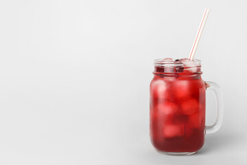 Mason jar with healthy cranberry juice on light background