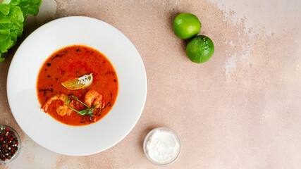 tom yum in white plate on concrete background. Spicy Thai food with ingredients on table. Spicy Thai food top view