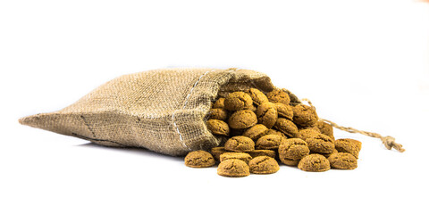 Traditional pepernoten treats in jute bag on white background