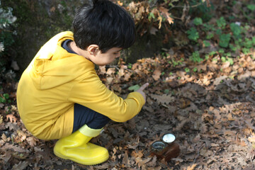 Child orienting himself with a compass on a hiking trail. the focus is on the compass.