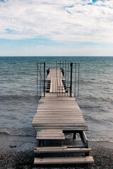 Fototapeta premium wooden pier in the sea on a cloudy day. Sea autumn landscape