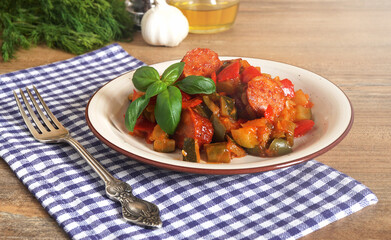 close-up of vegetable stew, eggplant, onion, zucchini with tomato sauce, garlic and herbs in a bowl on a wooden table, landscape view from above