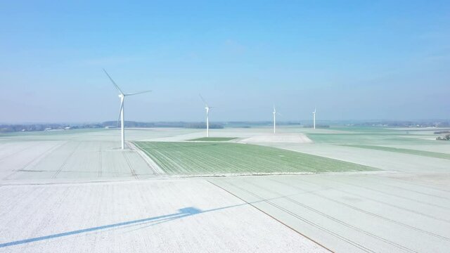 La neige recouvre les champs domin&eacute;s par les &eacute;oliennes en Europe, en France, en normandie, entre Dieppe et F&eacute;camp, en Hiver, lors d'une journ&eacute;e ensoleill&eacute;e.