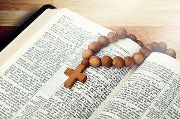 Humen christian read bible. Hands folded in prayer on a Holy Bible on wooden table.