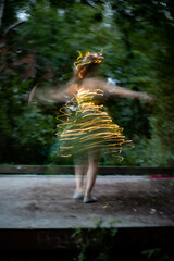 woman dressed in leaves and lights spinning around