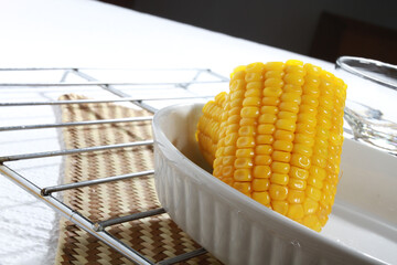 Piece of cooked corn on the white pla - obrazy, fototapety, plakaty