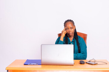 young black african woman sitting at office desk thinking of idea.