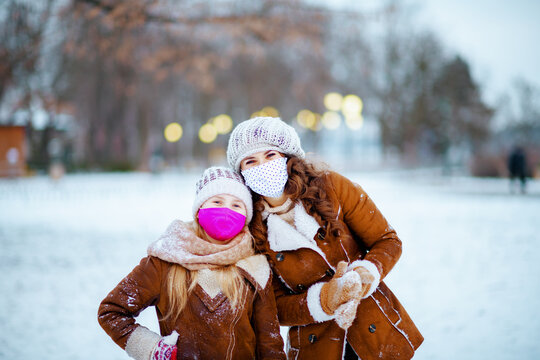 Stylish Mother And Child Outdoors In City Park In Winter