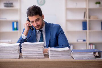 Young male employee unhappy with excessive work in the office