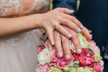 Obraz na płótnie Canvas Hands and rings on a wedding bouquet