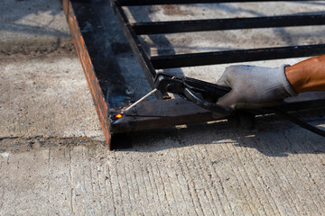 Iron gate repair, Worker hand welding steel