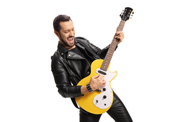 Young male musician in leather jacket and pants playing an electric guitar
