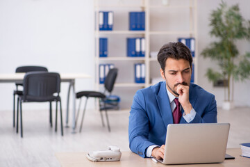 Young male employee working at workplace